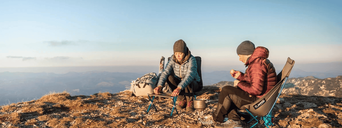 friends camping on mountain top with helinox camping chairs