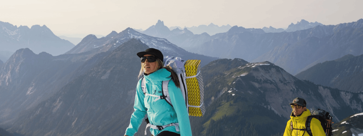 Man and woman hiking New Zealand Mountain in Outdoor Research gear and accessories