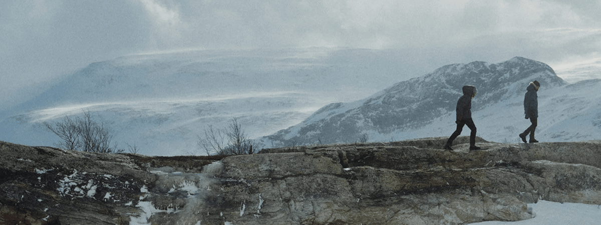 two hikers trekking through frozen tundra in fjallraven gear