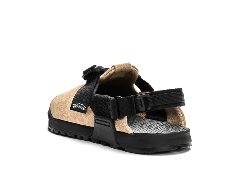 Tan and black sandal with a brand logo on a white background