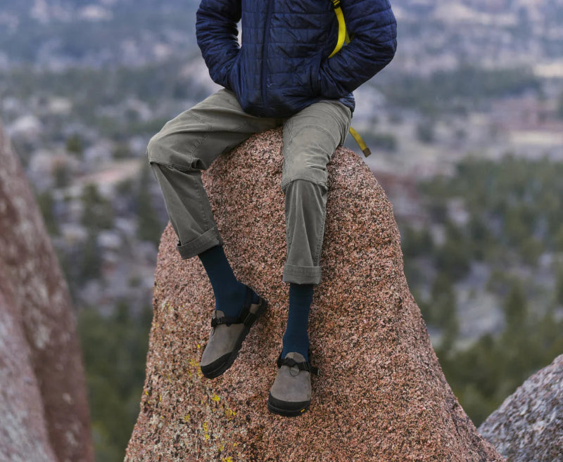 Person sitting on a rock with a scenic background