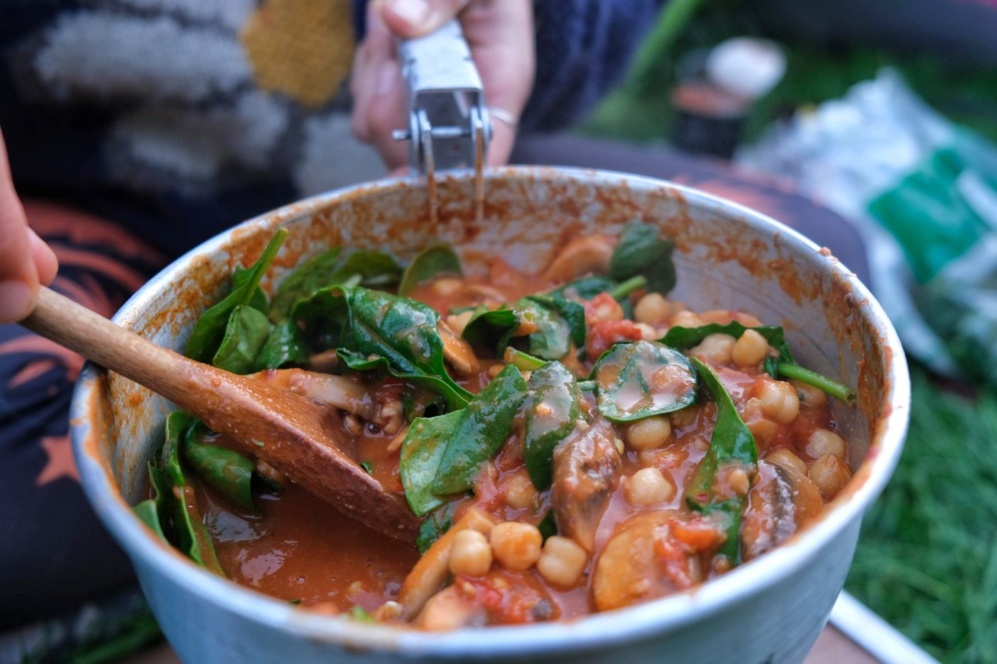 bowl of chickpea and spinach stew with a wooden spoon