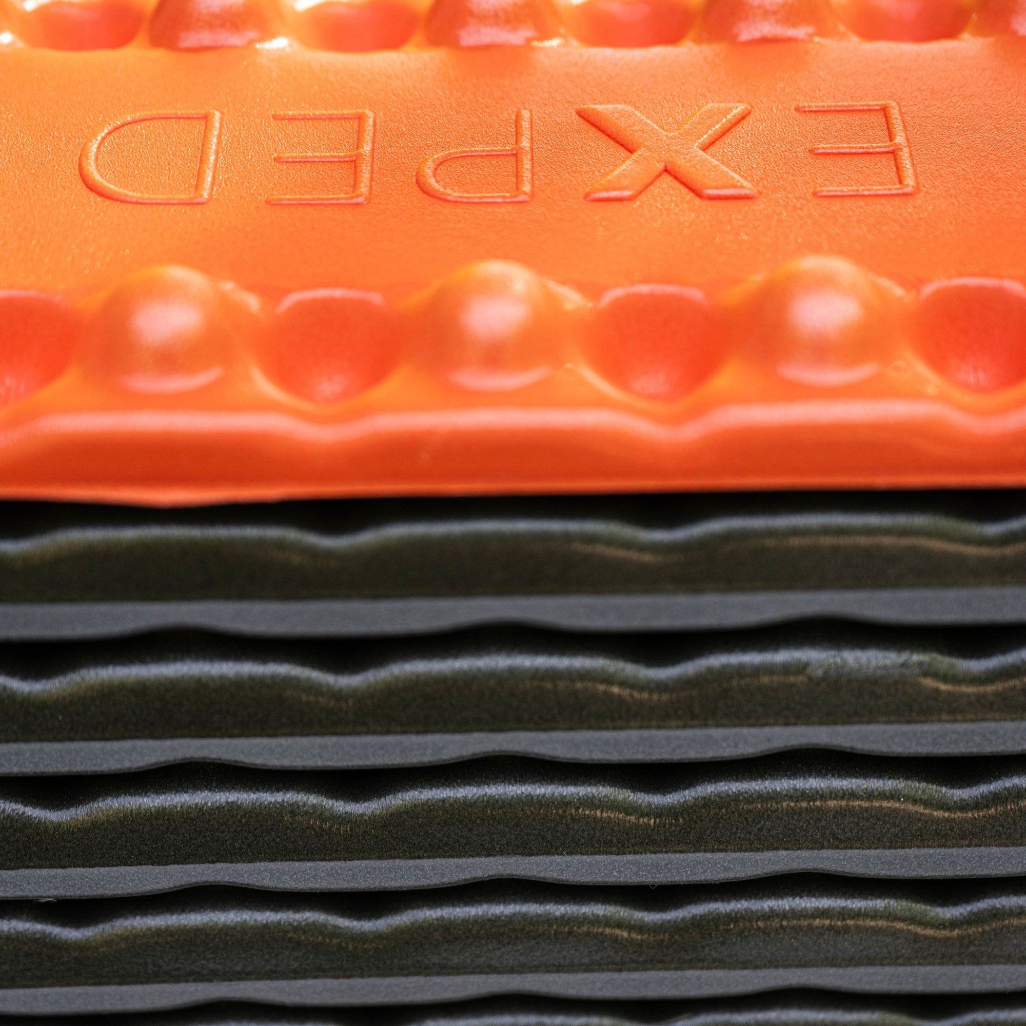 Close-up of orange and black foam padding with 'EXPED' branding.