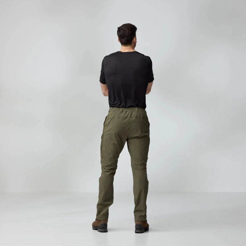 Person wearing olive green pants and a black shirt on a white background
