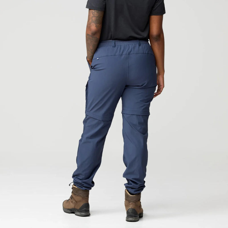 Person wearing blue pants and brown boots on a white background