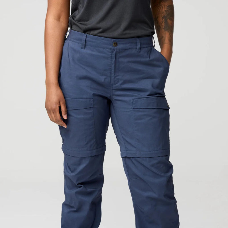 Person wearing blue cargo pants on a plain background