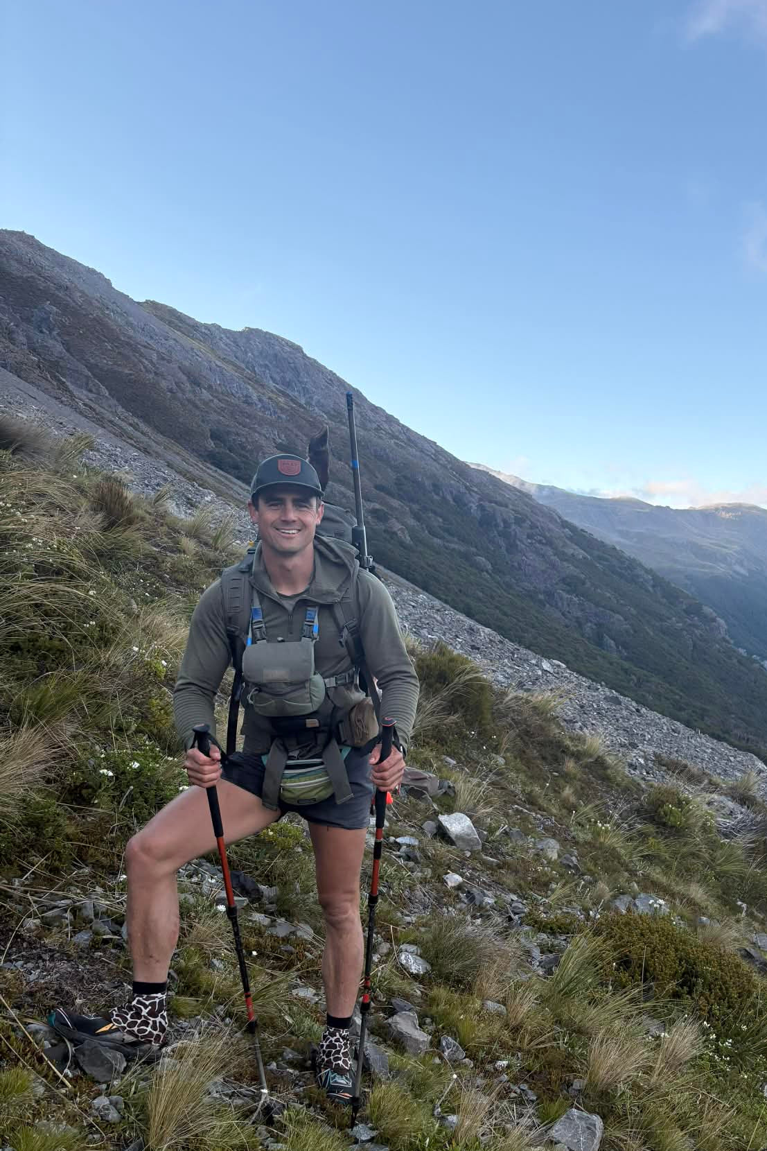 Male hiking in New Zealand South Island with backpack and trekking poles as a tour guide.