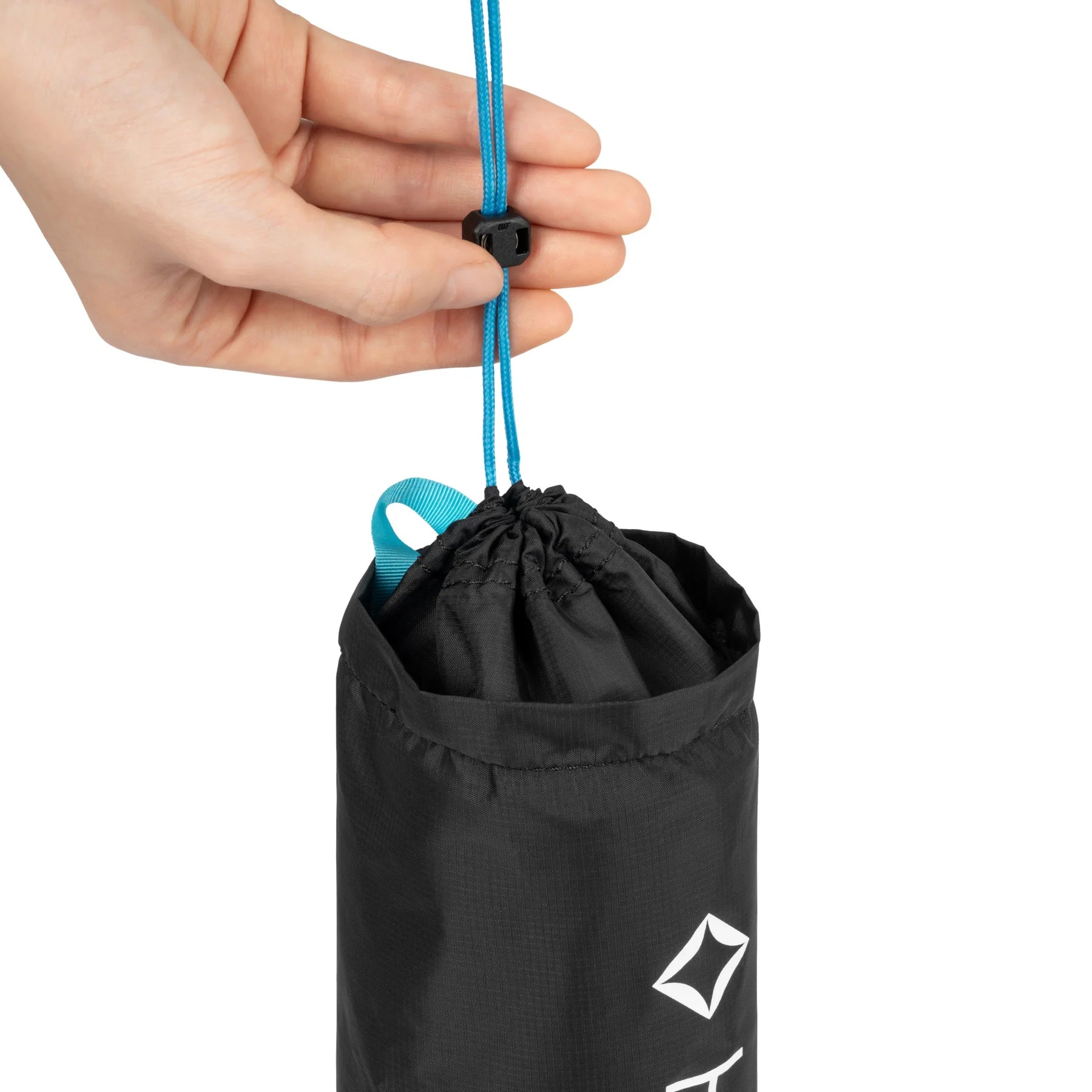 Black drawstring Helinox Camping Table bag with a brand logo held by a hand against a white background