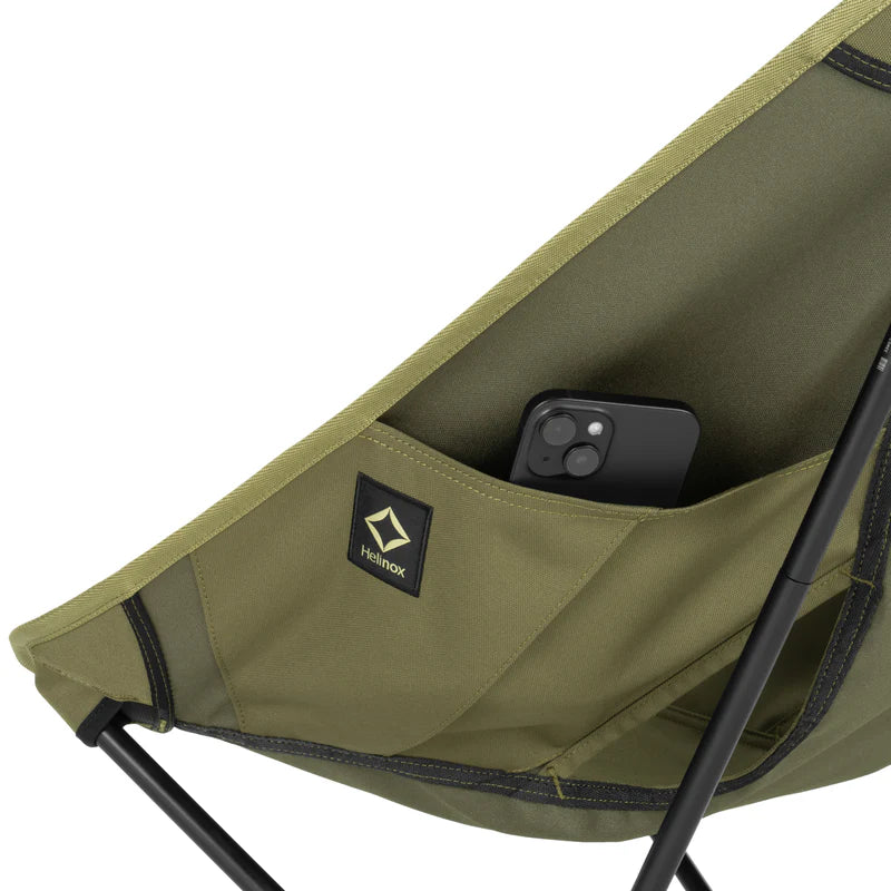 Green camping chair with a pocket holding a phone on a white background