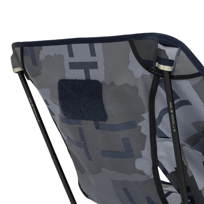 Close-up of a camouflage-patterned chair with a patch on a white background