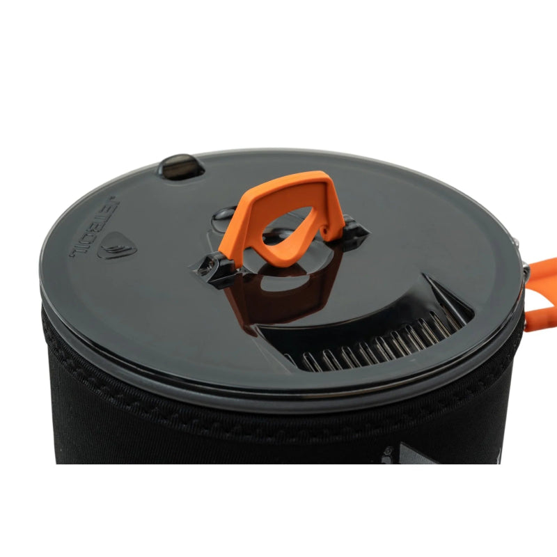 Black and orange lid of a camping stove on a white background