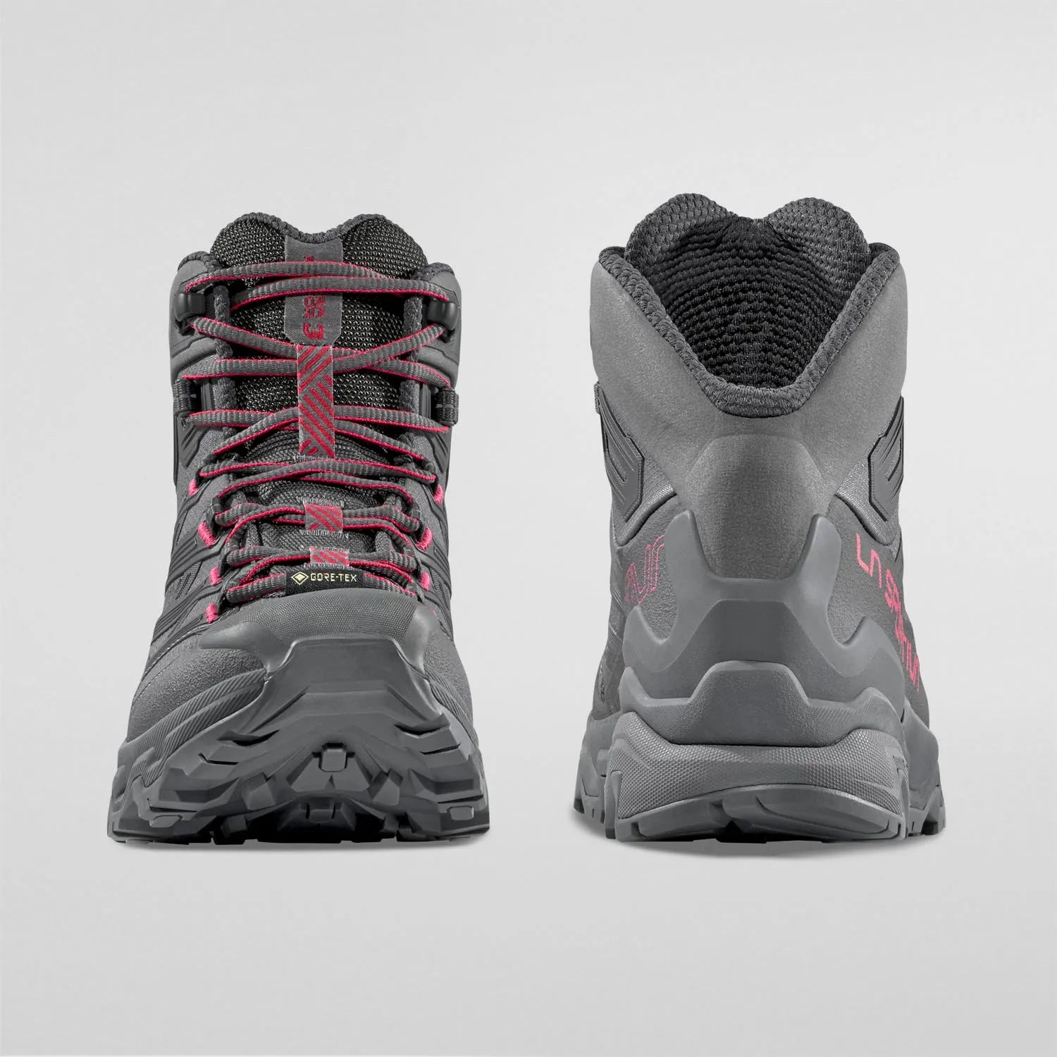 Pair of gray womens hiking hiking boots with red accents on a light gray background