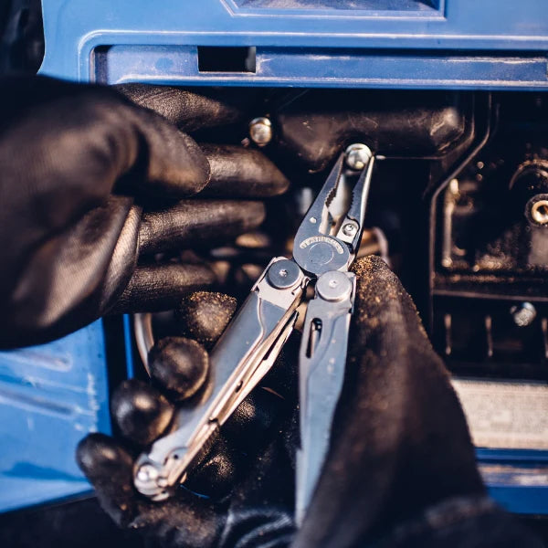 Close-up of hands using a multi-tool with a blue tool box in the background