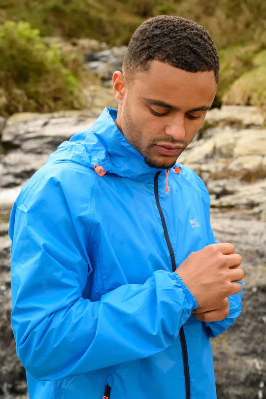 Man wearing a blue rain jacket looking down at the cuff of his rain jacket on his wrist