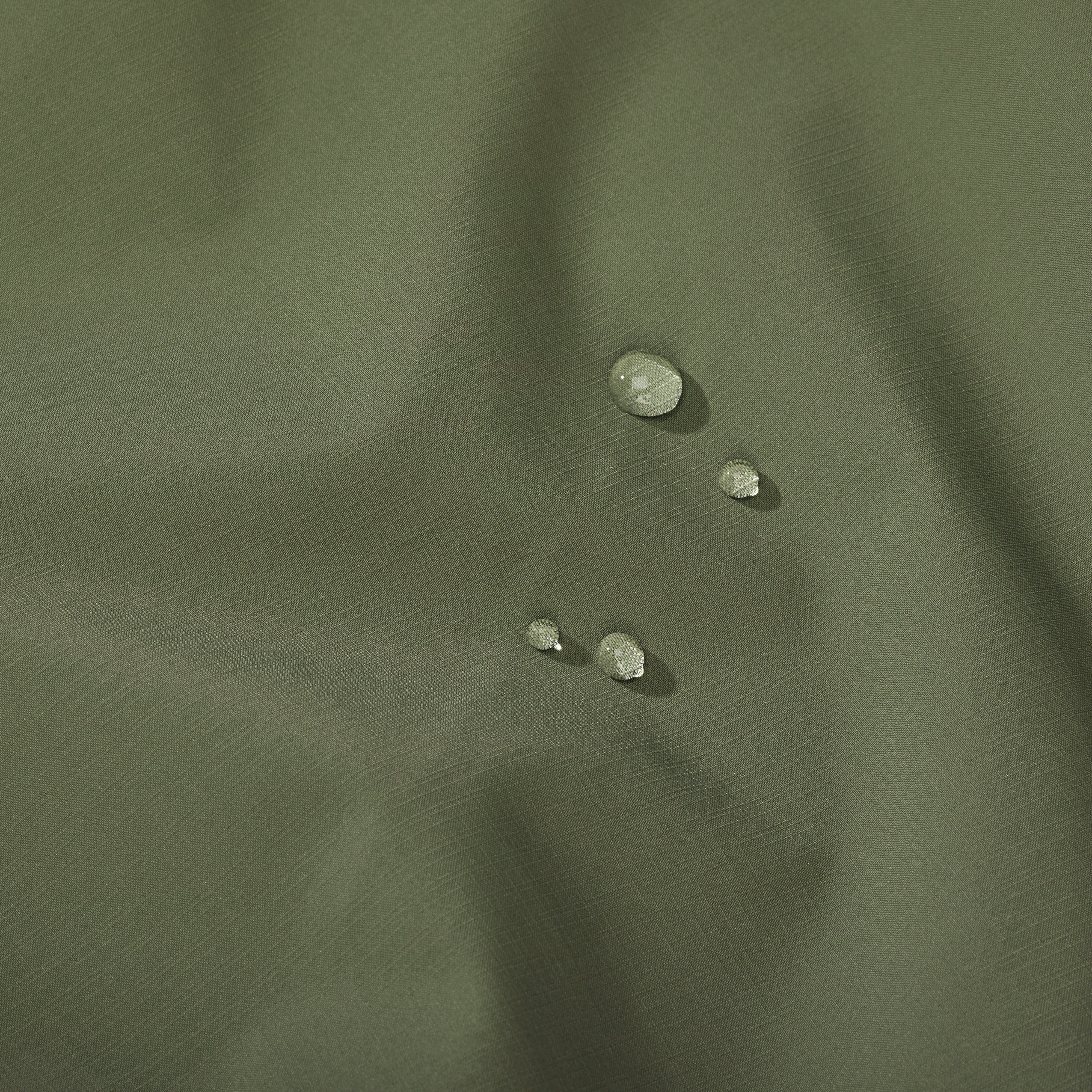 Water droplets on a green fabric surface