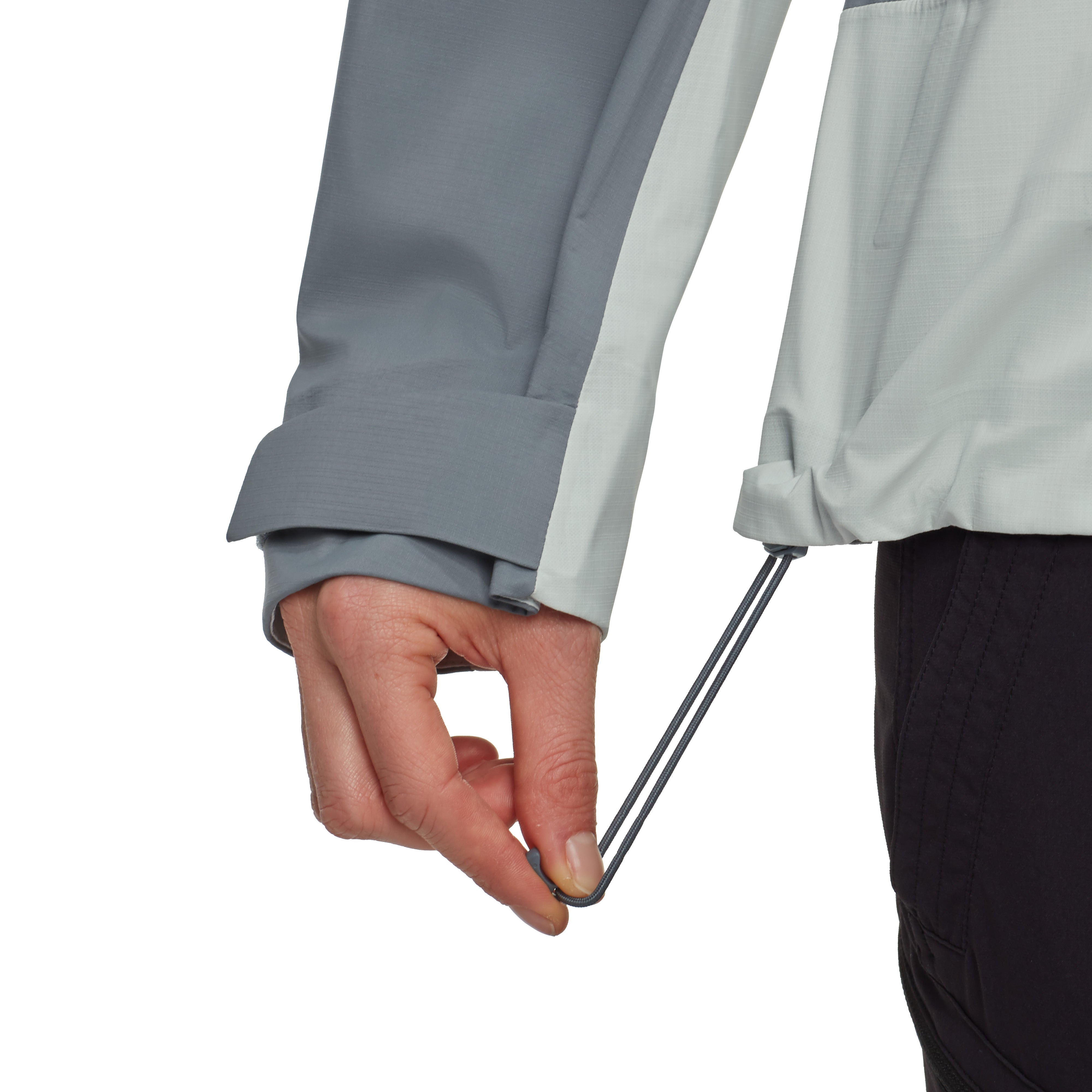 Person adjusting a drawstring on a gray jacket against a white background