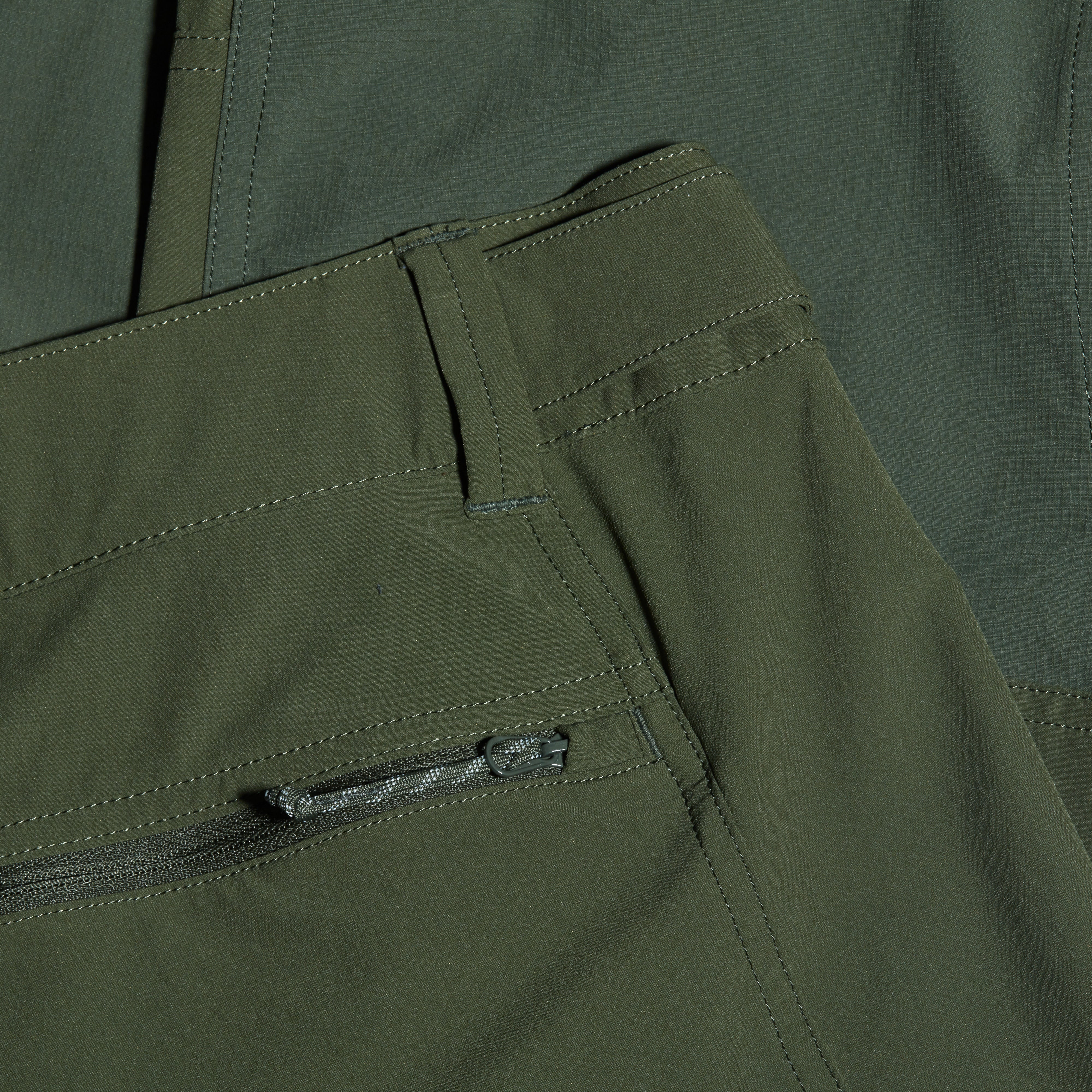 Close-up of green pants with a zipper pocket
