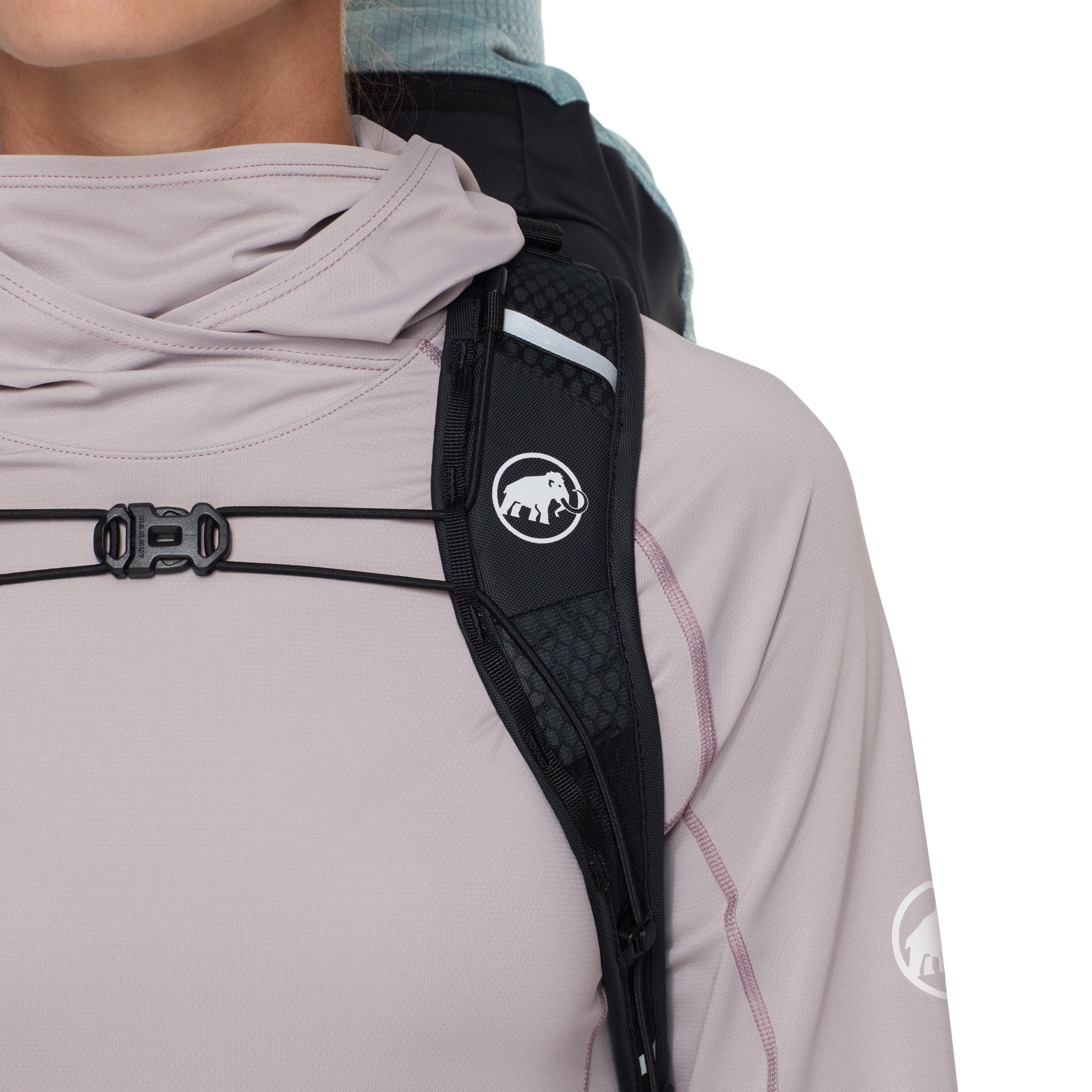 Person wearing a light pink jacket with a black shoulder strap and logo, on a white background