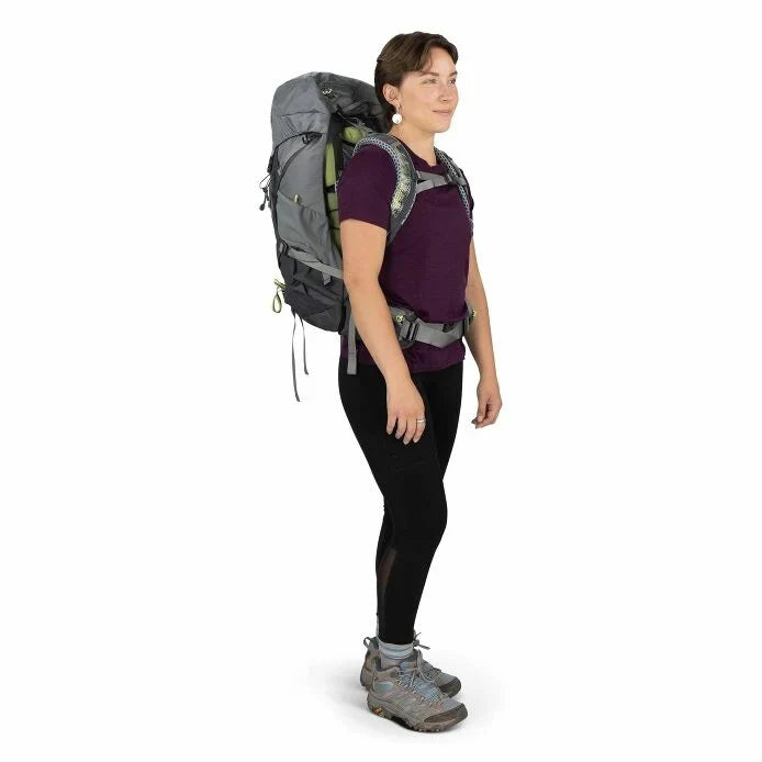 Person wearing a large gray backpack on a white background