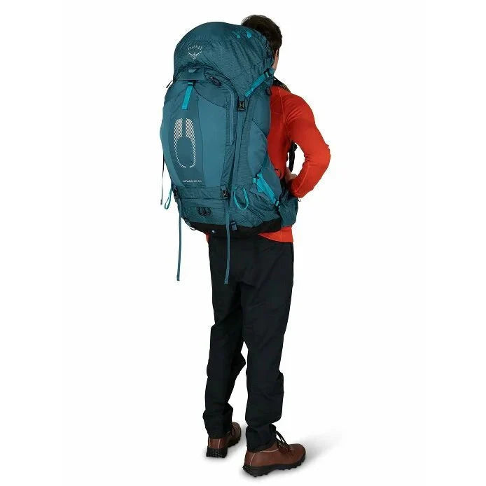 Person wearing a large teal backpack on a white background
