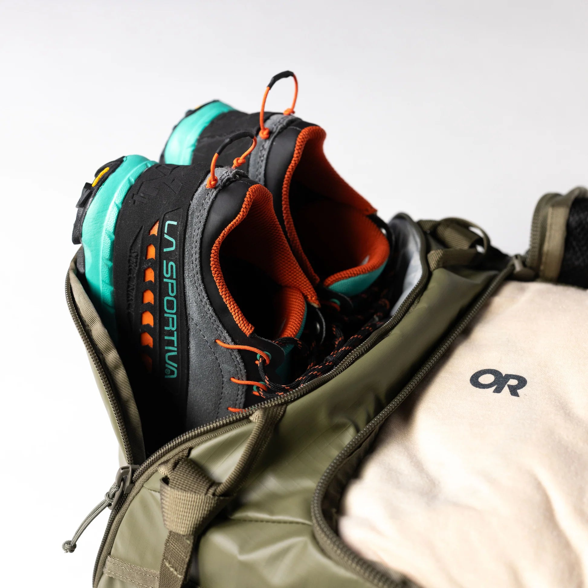 La Sportiva climbing shoe inside an open backpack with OR logo.