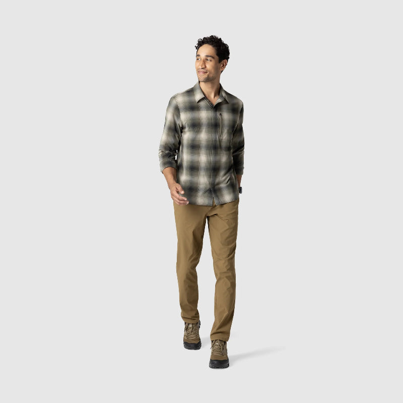 Man wearing a plaid shirt and brown pants on a white background