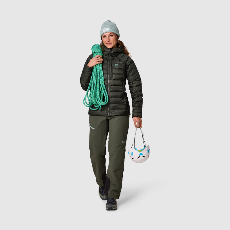 Person wearing outdoor gear with climbing equipment on a plain background