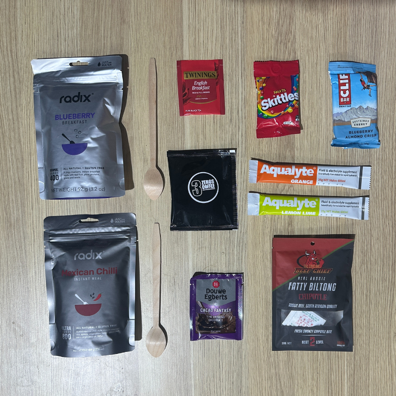 Assorted food and snack packages on a wooden surface