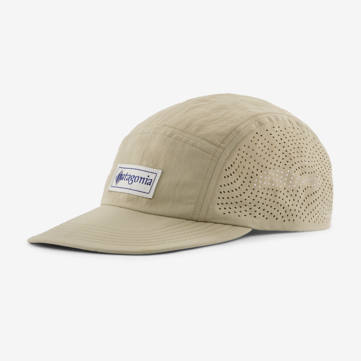 A beige Patagonia 5-panel camp cap with a curved brim, featuring a white brand patch on the front and perforated side panels, shown on a light gray background.