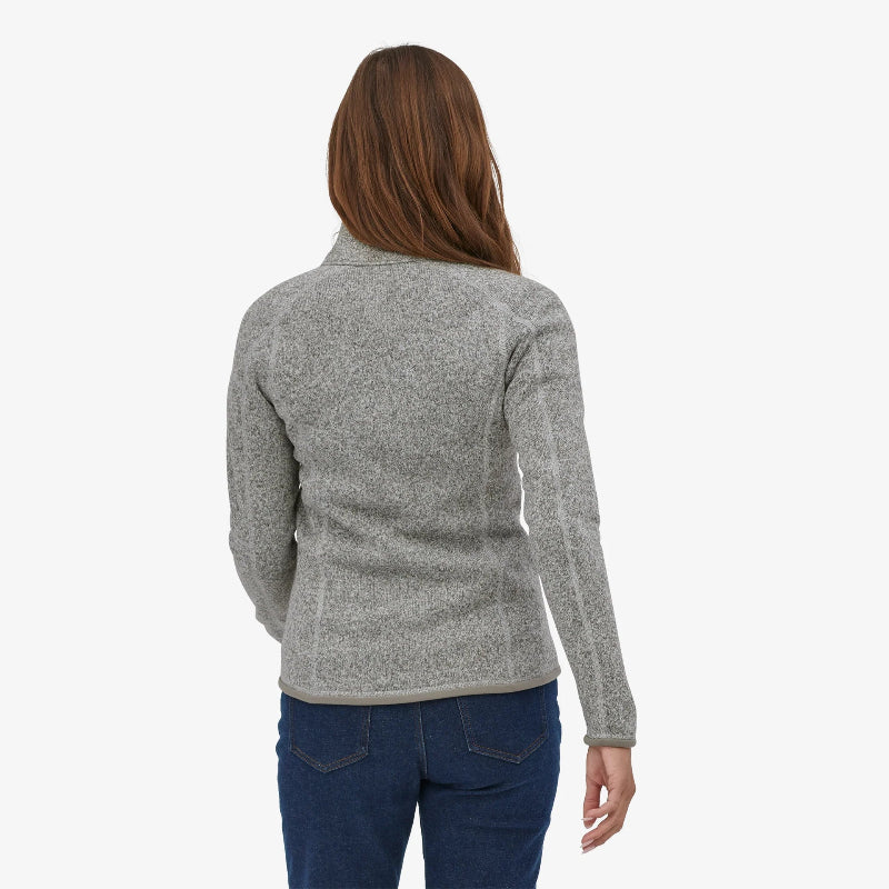 Woman facing away from the camera wearing the birch white Patagonia Women's Better Sweater Fleece Jacket and jeans