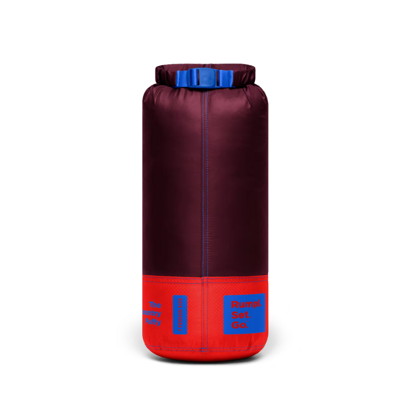 A cylindrical dry bag or storage sack in dark burgundy with a bright red base and blue accents, including a blue top closure and blue printed labels, shown on a plain white background.