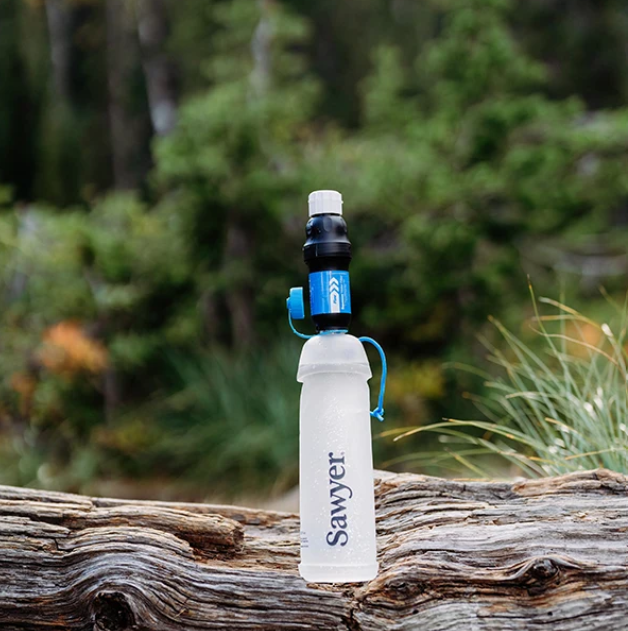 Sawyer Squeeze Water Filtration System w/ Cnoc 1L Bottle on a log