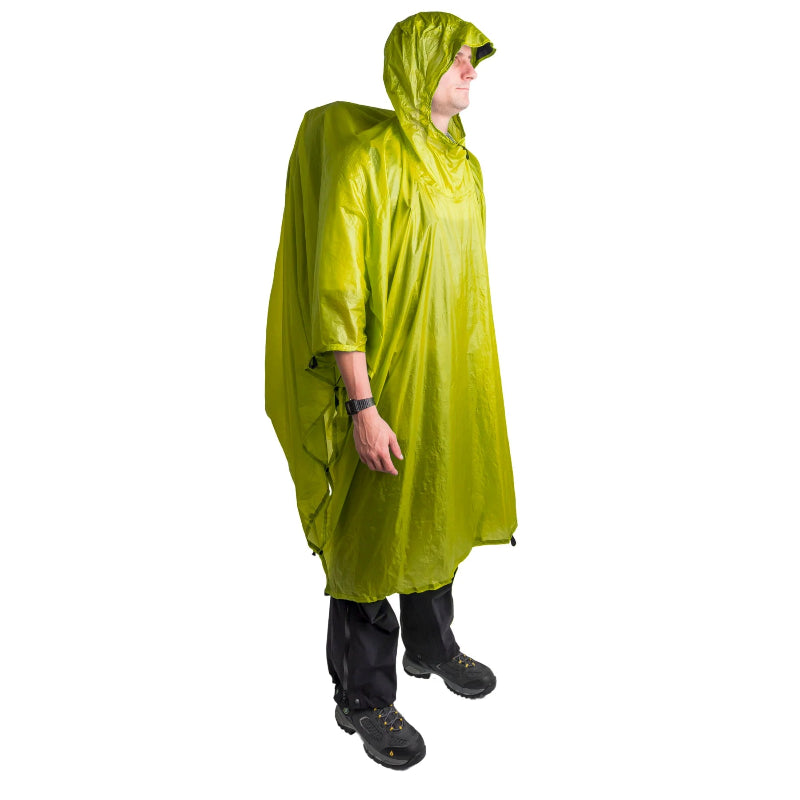 Person wearing a green rain poncho on a white background