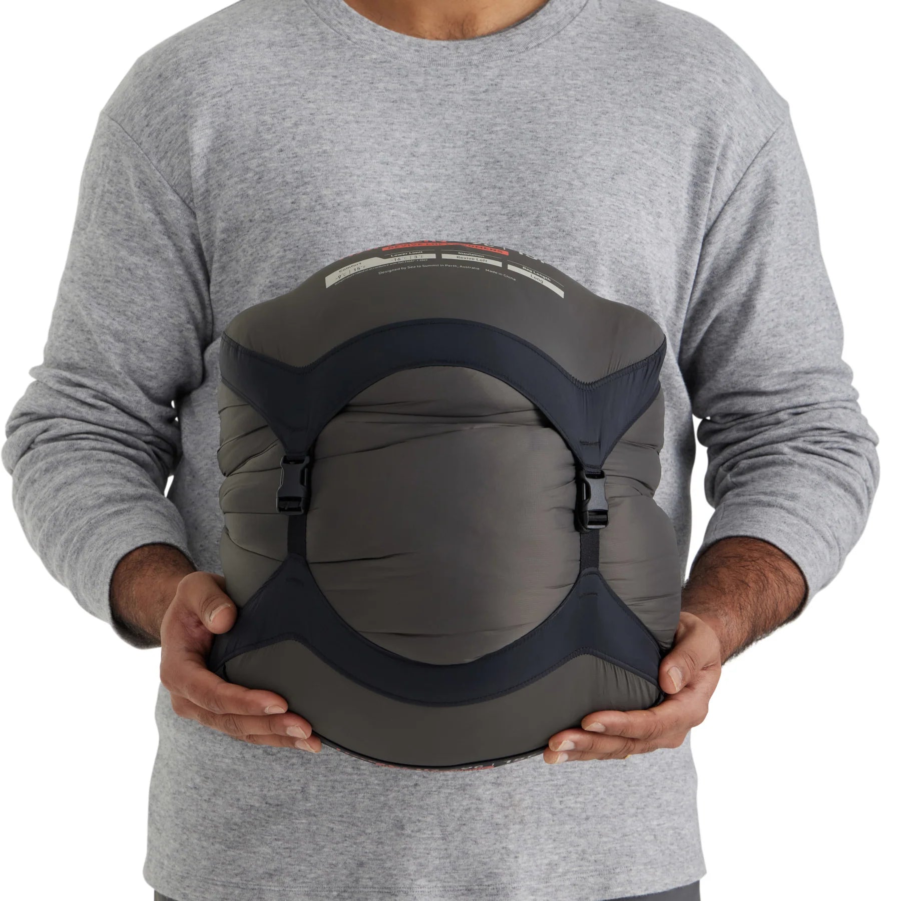 Person holding a gray and black compression bag against a white background