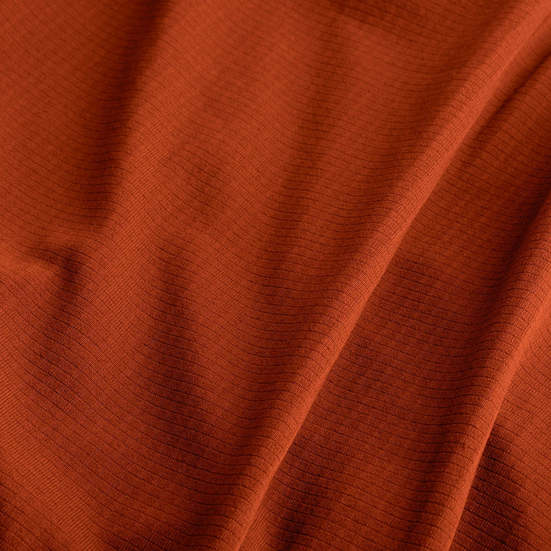 Close-up of rust-colored fabric with visible texture
