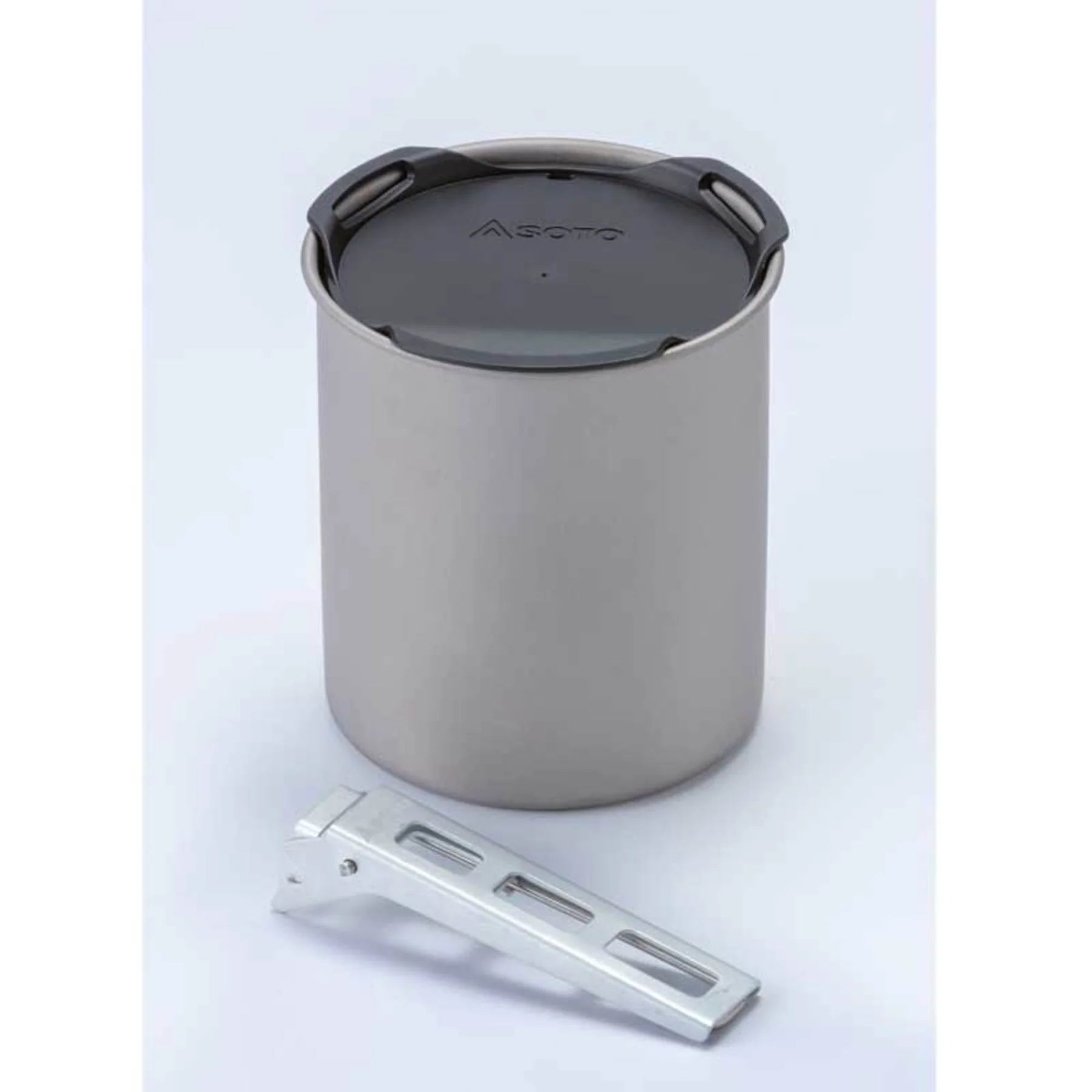 Metal camping pot with a lid on a light gray background