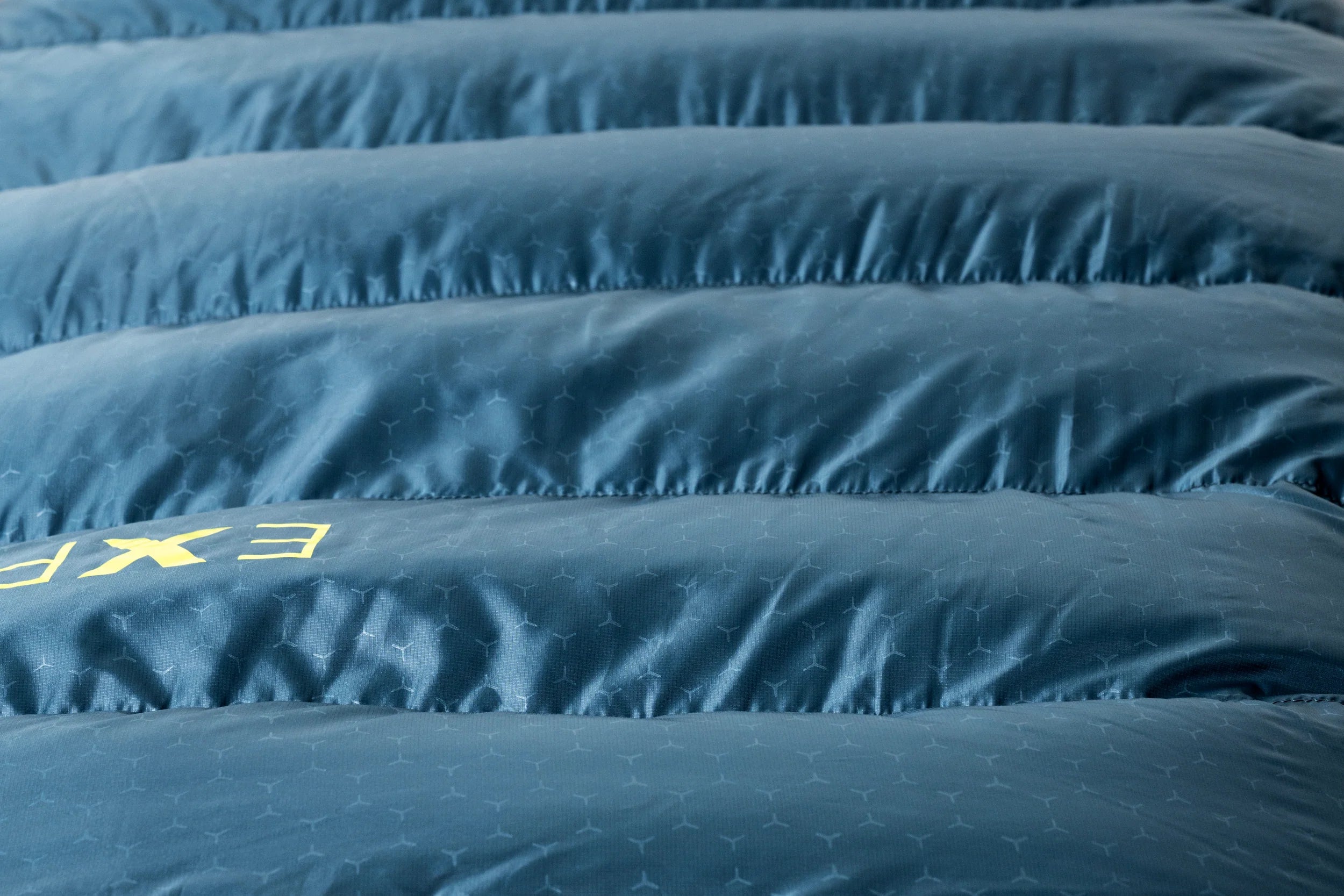 Close-up of a blue lightweigt sleeping bag hiking with visible branding