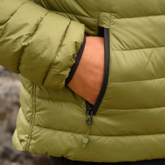 Close-up of a person wearing a green puffer jacket with a zipper pocket.