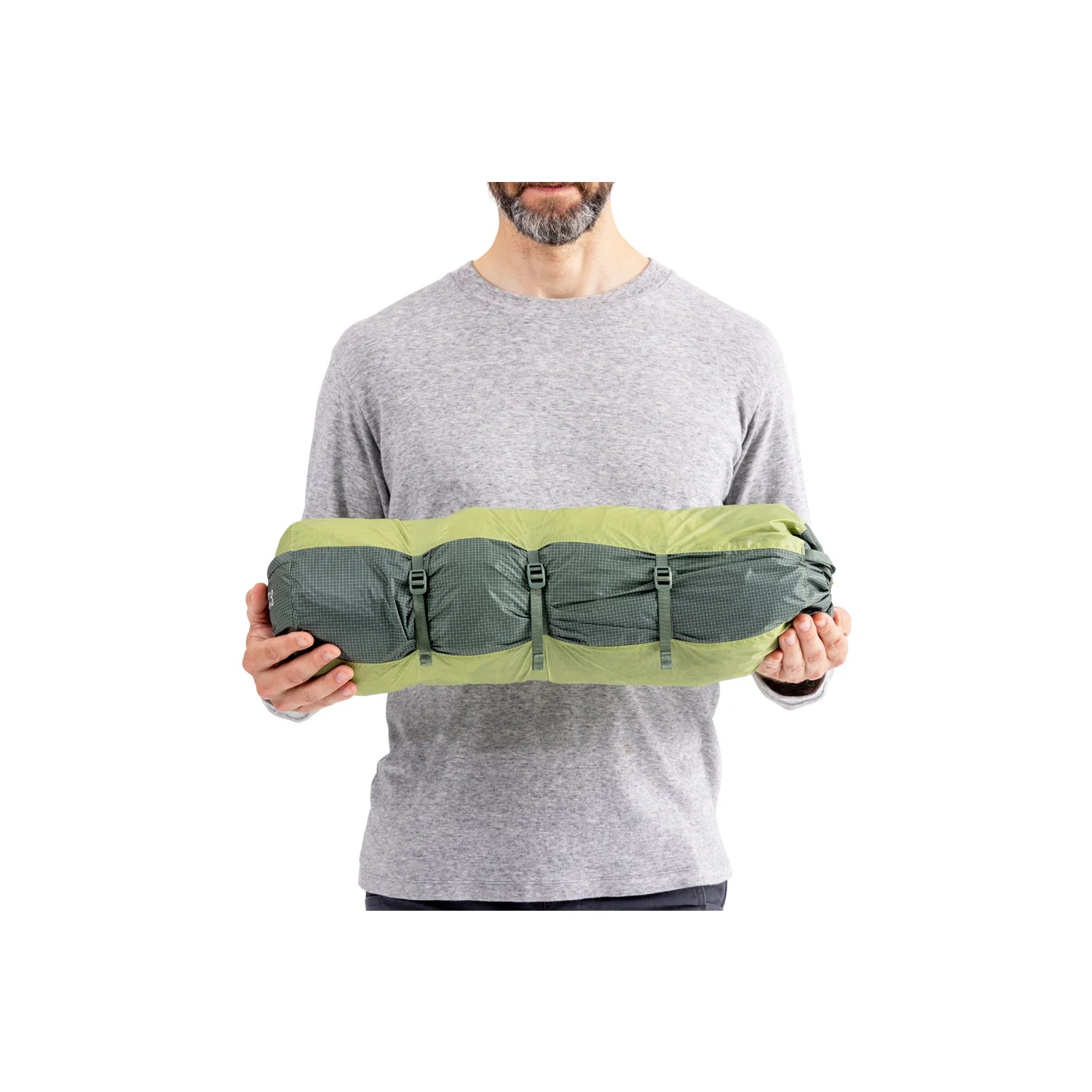 Person holding a green and gray bag against a white background