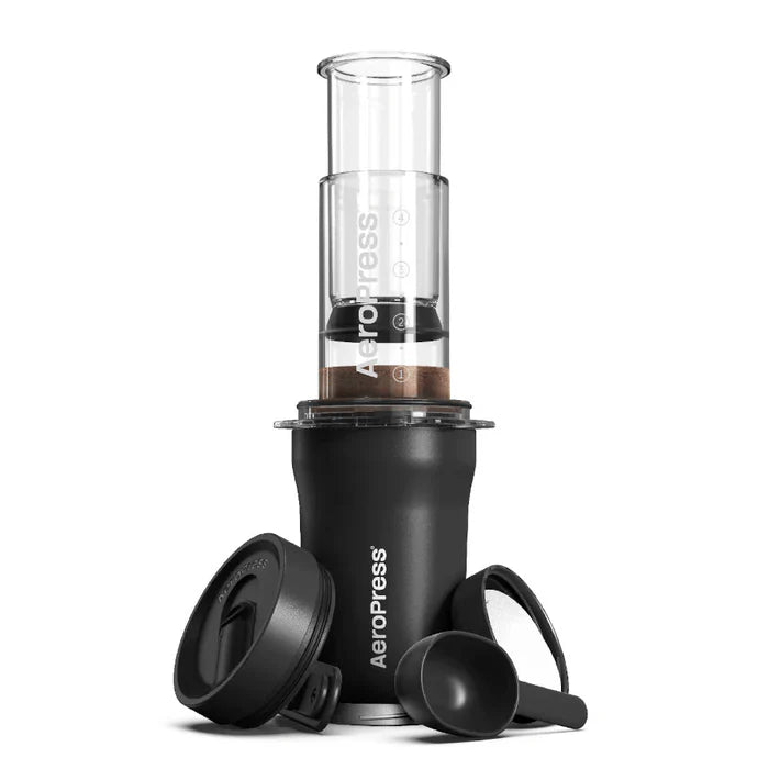 Black Aeropress coffee maker with a clear chamber on a white background