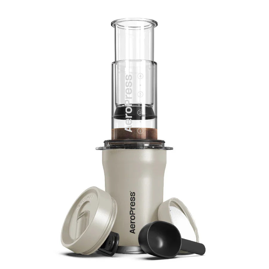 AeroPress coffee maker with a clear chamber and beige base on a white background