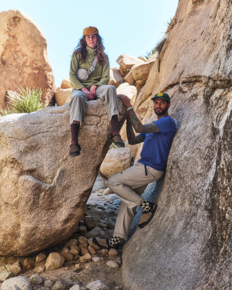 Two people resting on mountainous rocks wearing the bedrock sandals mountain clogs