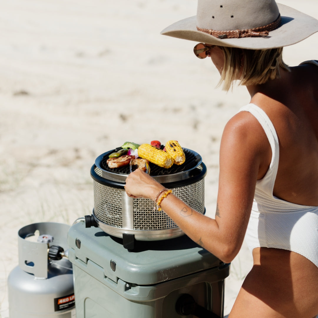 A cobb grill LPG gas being used on the beach
