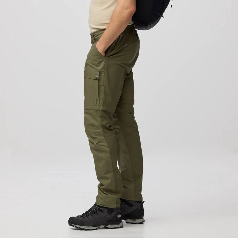 Person wearing olive green hiking pants on a white background