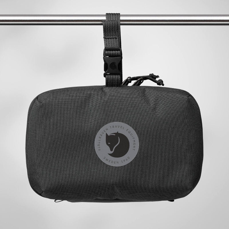 Black travel pouch with a brand logo on a gray background
