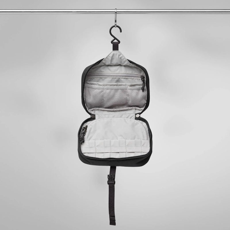 Black travel organizer with open compartments on a gray background
