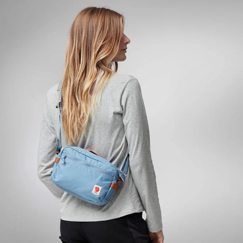 Person wearing a blue bag on a plain background