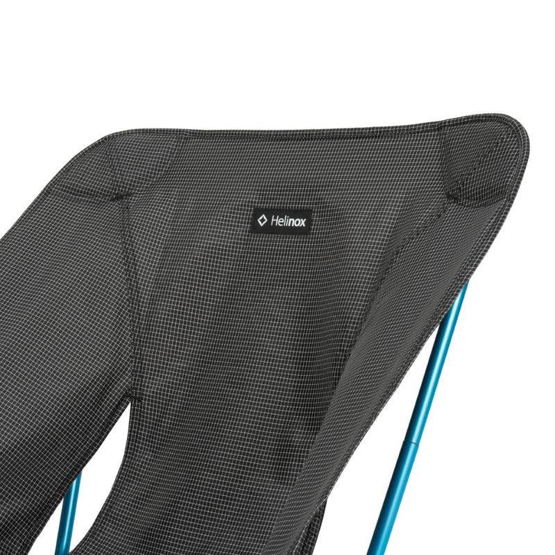Black Helinox chair with blue legs on a white background