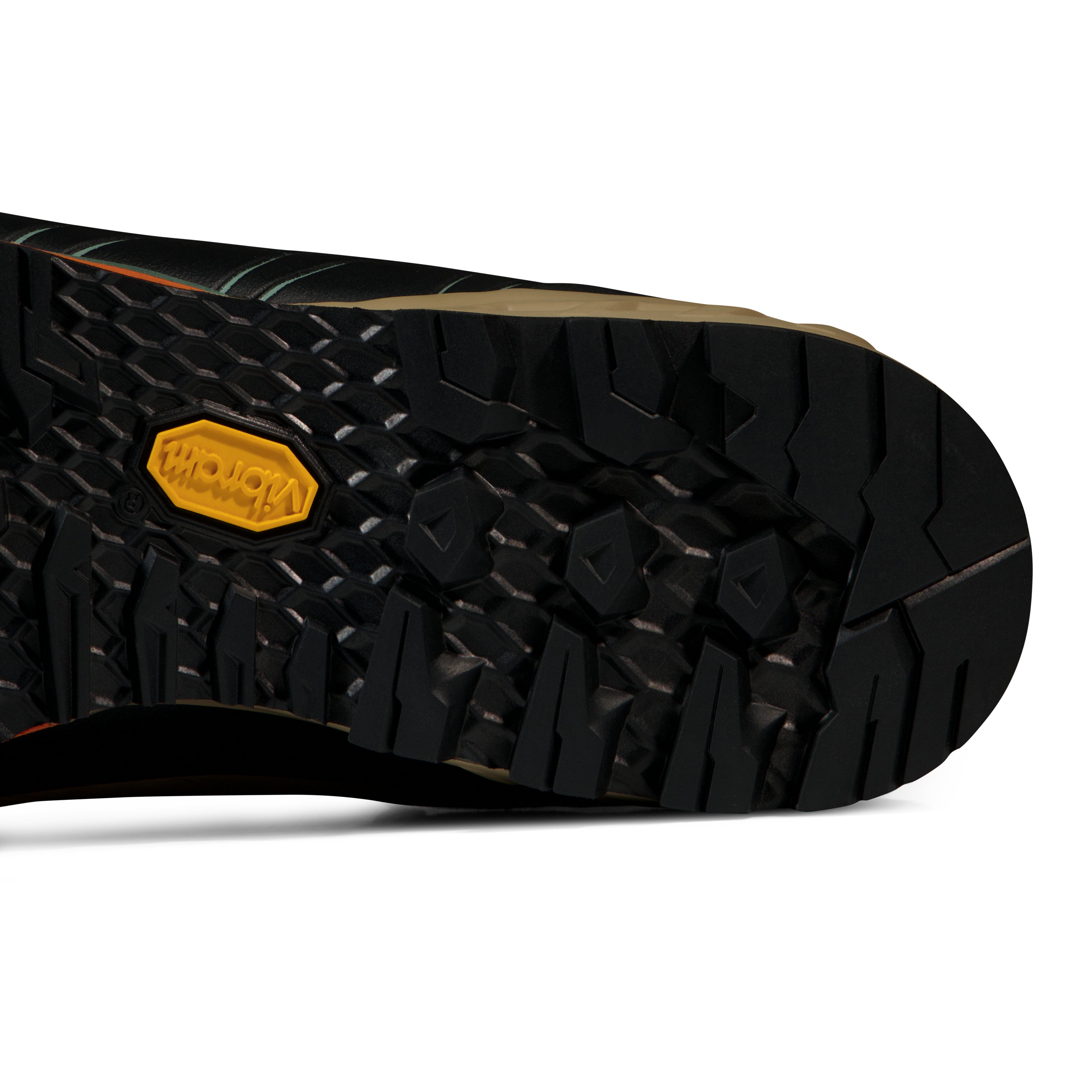 Close-up of a black shoe sole with a yellow brand logo on a white background