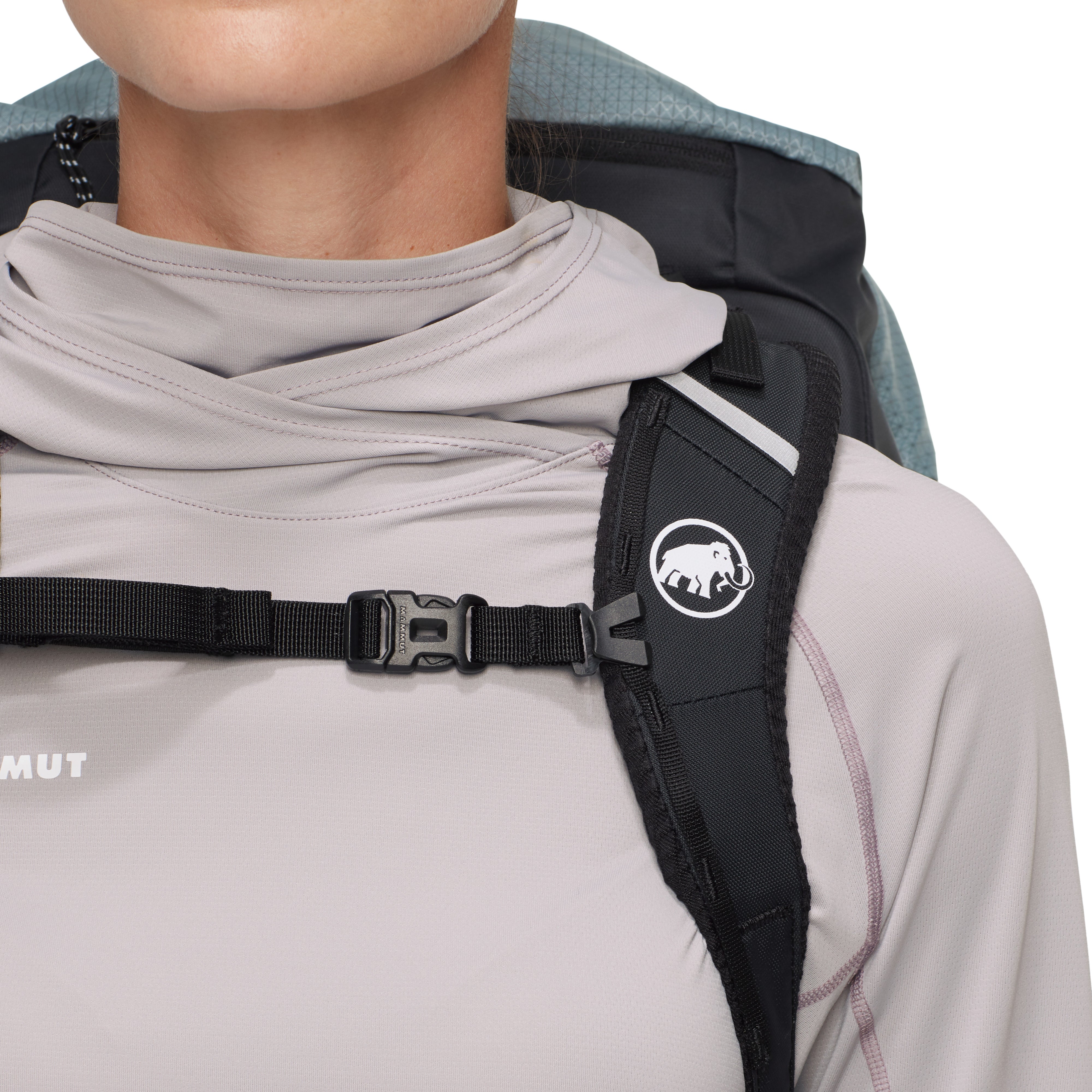 Person wearing a backpack with a visible brand logo on the shoulder strap.